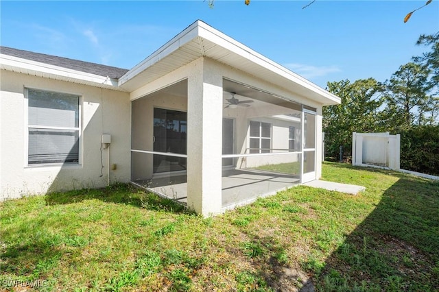 view of home's exterior featuring a lawn, a sunroom, and stucco siding