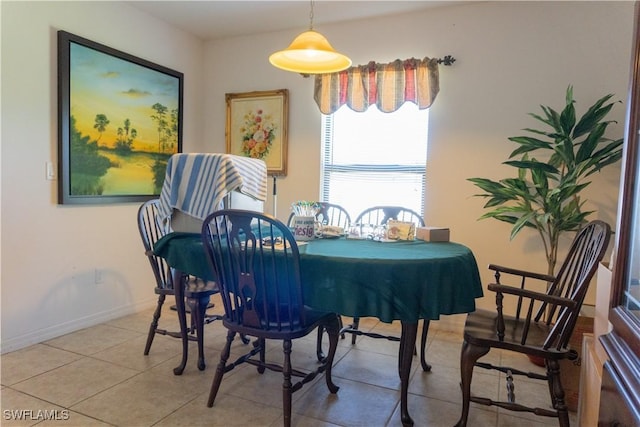 dining space featuring light tile patterned floors and baseboards