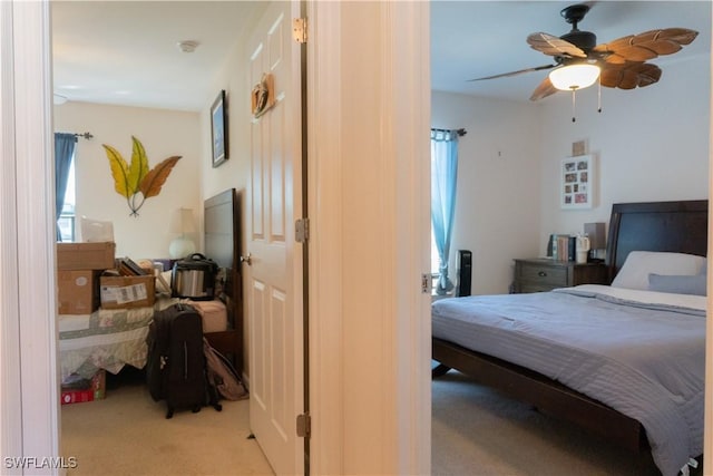 bedroom featuring multiple windows, light colored carpet, and ceiling fan