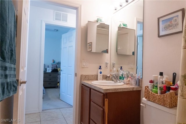 bathroom featuring visible vents, toilet, vanity, and tile patterned flooring