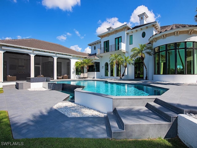 pool featuring a patio and a sunroom