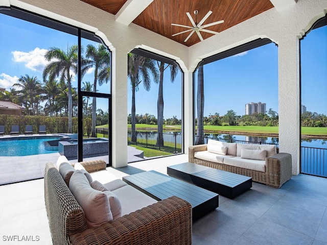 view of patio featuring a water view, a pool with connected hot tub, an outdoor living space, fence, and ceiling fan