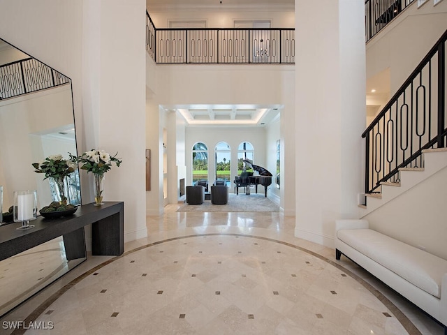 entrance foyer with ornamental molding, french doors, baseboards, a towering ceiling, and stairs