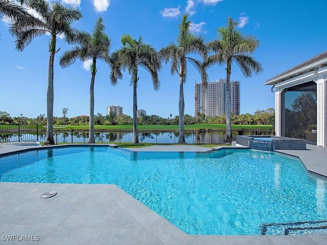 view of swimming pool featuring a patio area, a water view, a pool with connected hot tub, and fence