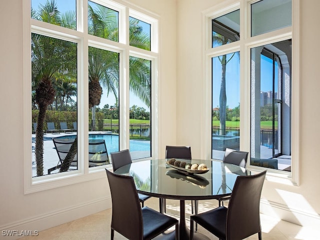 tiled dining room featuring baseboards and a wealth of natural light