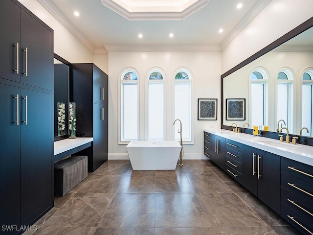 bathroom featuring double vanity, a freestanding tub, recessed lighting, and crown molding