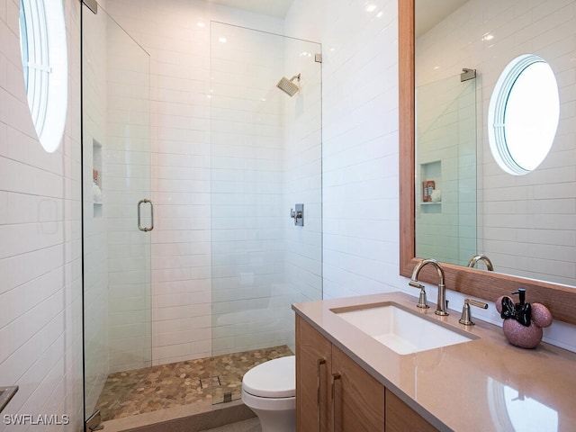 full bath featuring toilet, tile walls, a stall shower, and vanity