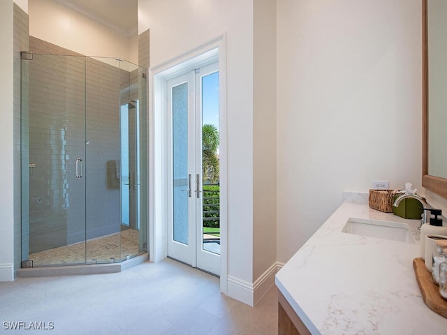 full bath with crown molding, baseboards, a stall shower, french doors, and vanity