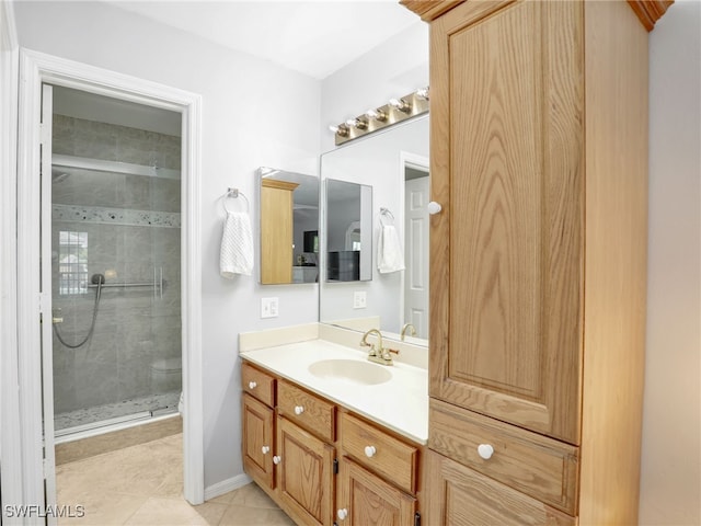 bathroom with tile patterned flooring, a shower stall, vanity, and baseboards