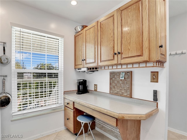 office area with a wealth of natural light, baseboards, and light tile patterned floors