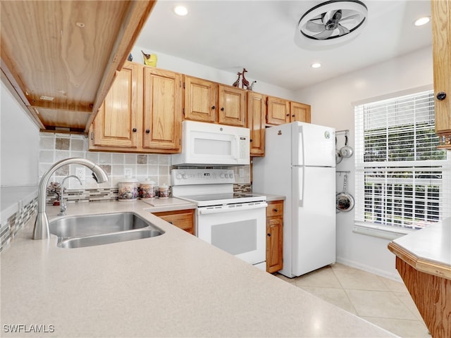 kitchen featuring white appliances, light countertops, tasteful backsplash, and a sink