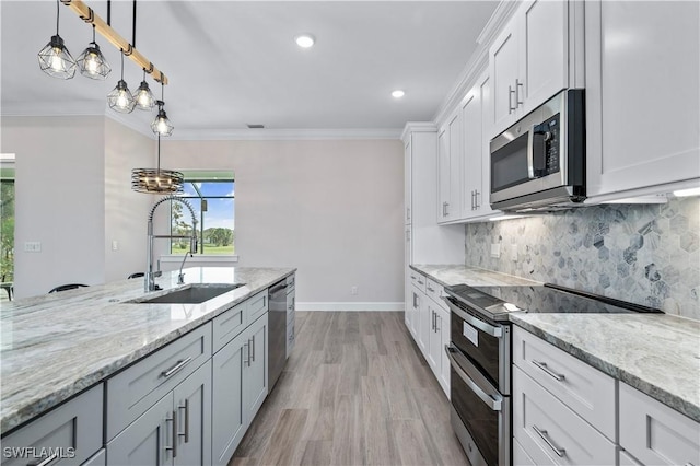 kitchen with a sink, tasteful backsplash, appliances with stainless steel finishes, and crown molding