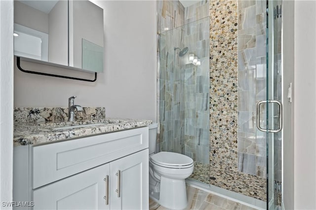 full bathroom with a shower stall, toilet, and vanity