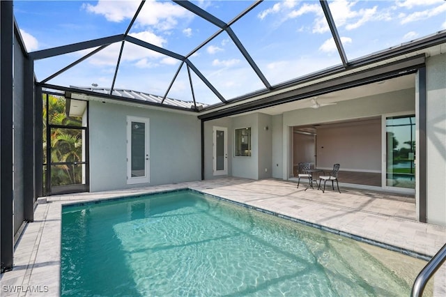 pool featuring glass enclosure and a patio