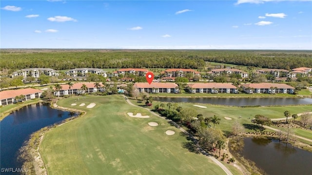 drone / aerial view with a water view and golf course view