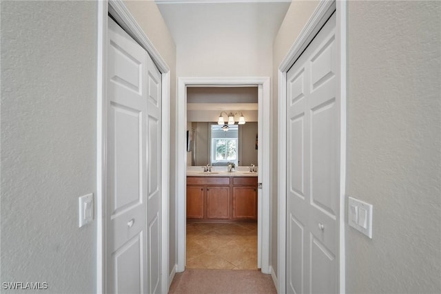 hall with light tile patterned floors and a sink