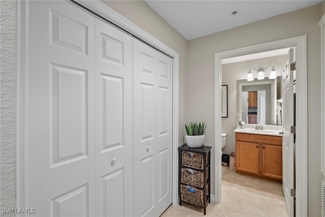 bathroom featuring vanity, tile patterned floors, toilet, and a closet