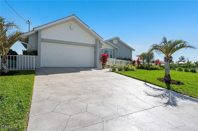 ranch-style house featuring a front lawn, an attached garage, driveway, and stucco siding