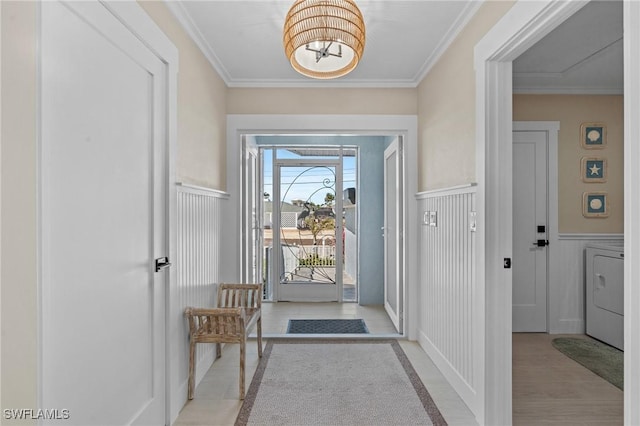 doorway to outside featuring washer / dryer, ornamental molding, wainscoting, and an inviting chandelier