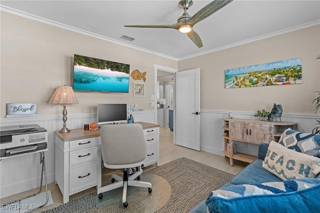 office area with ornamental molding, a ceiling fan, visible vents, and wainscoting