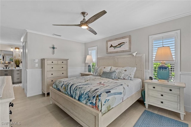 bedroom featuring visible vents, wainscoting, crown molding, and wood finished floors