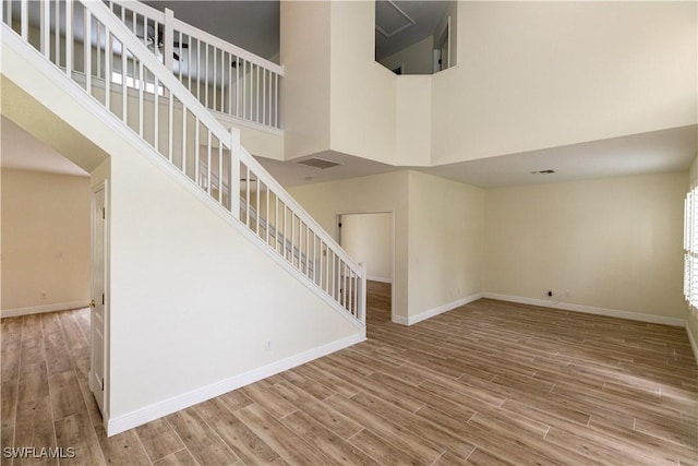 12391 Muddy Creek Ln, Fort Myers, FL 33913 - unfurnished living room with a towering ceiling, wood finished floors, baseboards, and stairs
