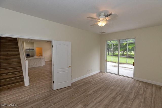 12391 Muddy Creek Ln, Fort Myers, FL 33913 - spare room with wood finished floors, baseboards, a ceiling fan, and a sink