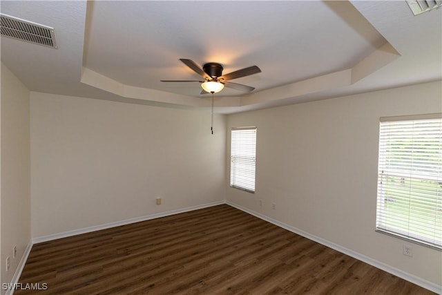 12391 Muddy Creek Ln, Fort Myers, FL 33913 - spare room featuring a tray ceiling, ceiling fan, dark wood-style flooring, and baseboards