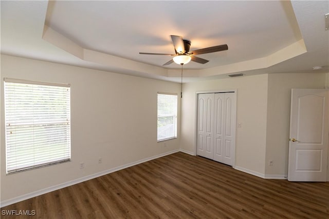 12391 Muddy Creek Ln, Fort Myers, FL 33913 - unfurnished bedroom featuring a tray ceiling, wood finished floors, baseboards, a closet, and ceiling fan