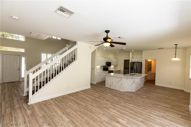 12391 Muddy Creek Ln, Fort Myers, FL 33913 - unfurnished living room with stairway, light wood-type flooring, ceiling fan, and recessed lighting