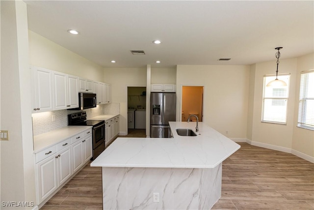 12391 Muddy Creek Ln, Fort Myers, FL 33913 - kitchen featuring appliances with stainless steel finishes, washing machine and dryer, tasteful backsplash, white cabinets, and recessed lighting