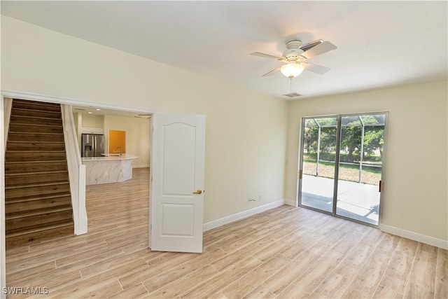 12391 Muddy Creek Ln, Fort Myers, FL 33913 - empty room featuring light wood-style floors, ceiling fan, and stairs