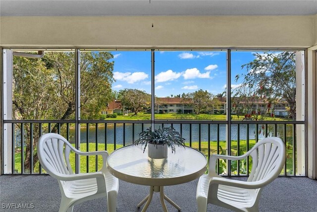 sunroom / solarium featuring a water view