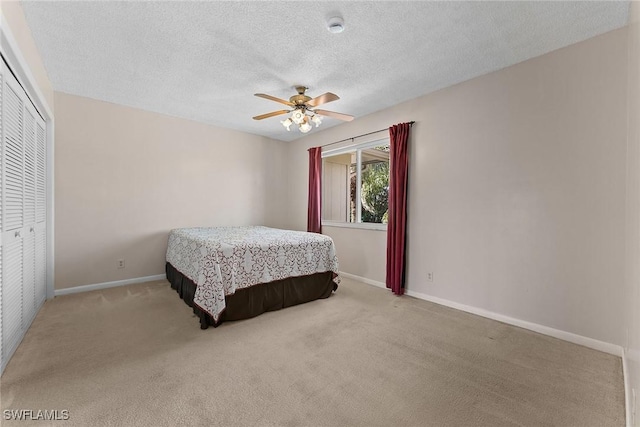 bedroom with baseboards, carpet flooring, a closet, a textured ceiling, and a ceiling fan