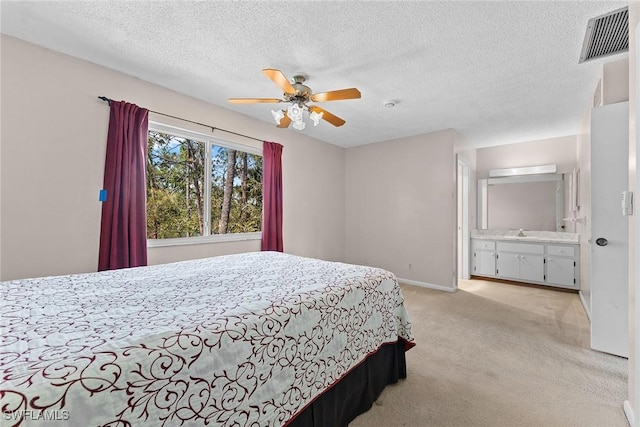 bedroom featuring a textured ceiling, baseboards, visible vents, and light carpet