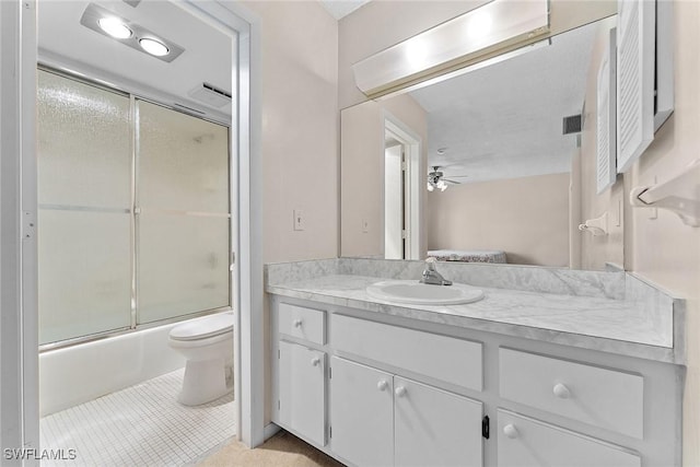 full bathroom with vanity, a ceiling fan, shower / bath combination with glass door, ensuite bath, and toilet