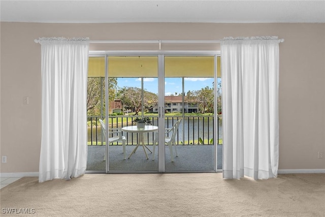 doorway with a water view, baseboards, and carpet floors