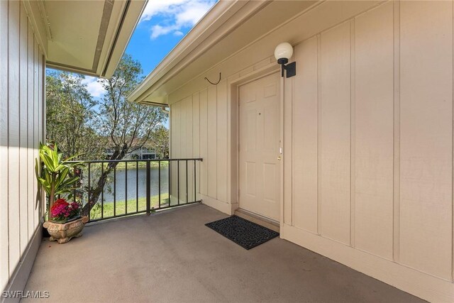 doorway to property with a balcony and a water view