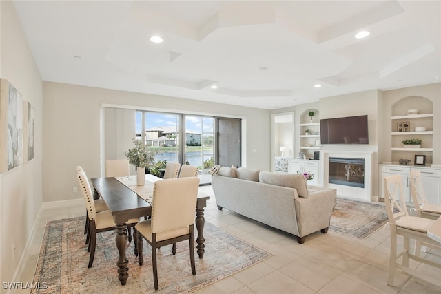 dining area with light tile patterned flooring, a glass covered fireplace, built in features, coffered ceiling, and recessed lighting