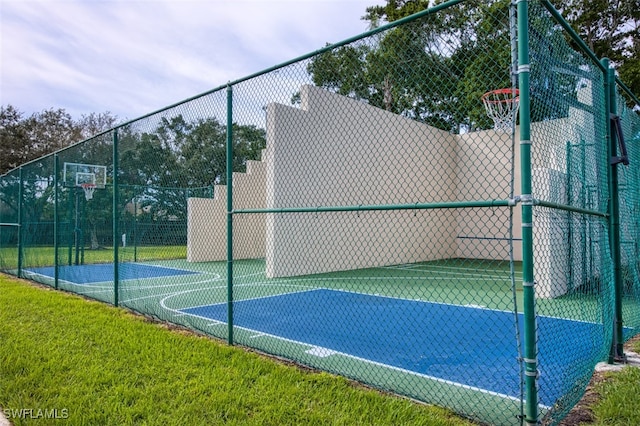 view of basketball court featuring community basketball court, a lawn, and fence