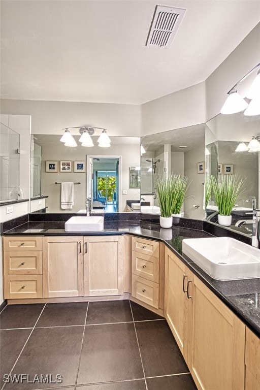 bathroom with tile patterned floors, visible vents, an enclosed shower, and vanity