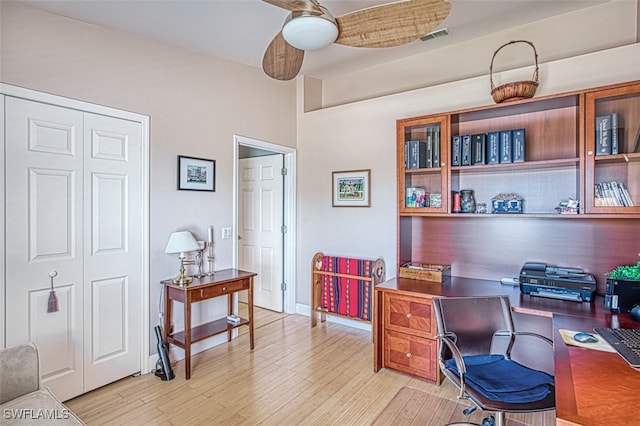 office space featuring light wood finished floors, visible vents, and baseboards