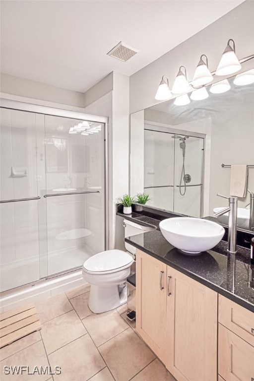 bathroom featuring visible vents, a shower stall, toilet, tile patterned floors, and vanity