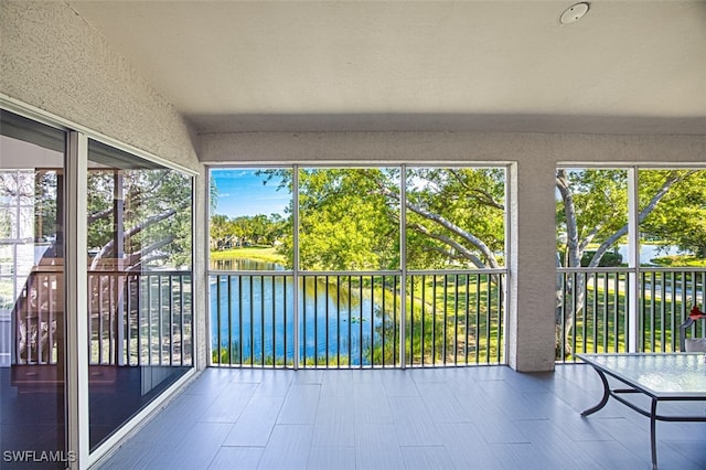 unfurnished sunroom with a healthy amount of sunlight and a water view