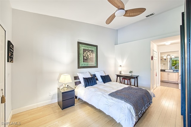 bedroom with baseboards, visible vents, light wood finished floors, ceiling fan, and ensuite bathroom