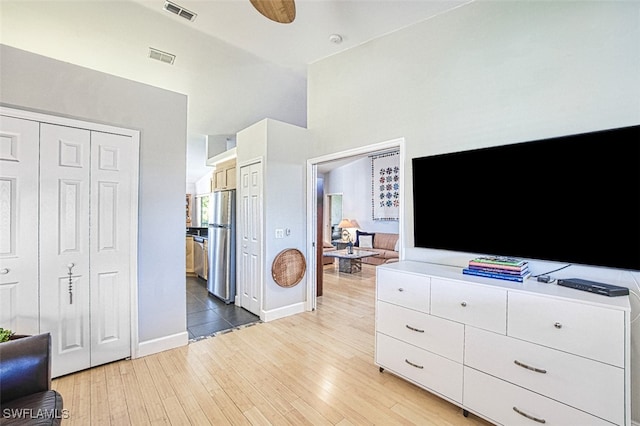 bedroom featuring visible vents, light wood finished floors, baseboards, and freestanding refrigerator