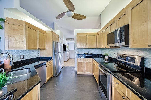 kitchen featuring a sink, backsplash, appliances with stainless steel finishes, and light brown cabinetry