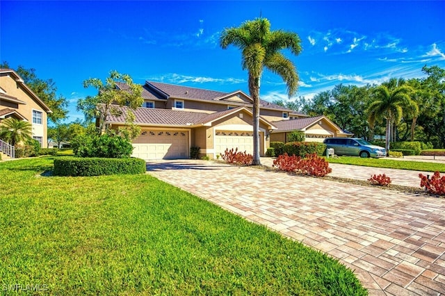 view of front of property featuring a standing seam roof, stucco siding, a garage, decorative driveway, and metal roof