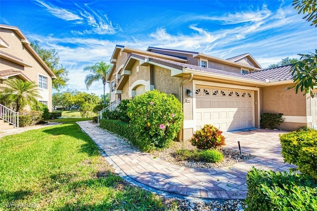 view of property exterior featuring stucco siding, decorative driveway, a garage, and a lawn