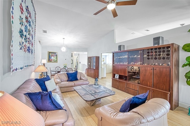 living area featuring visible vents, ceiling fan, lofted ceiling, and light wood-style floors